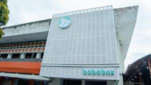un bâtiment avec une horloge sur son côté dans l'établissement Bobopod Alun-Alun, Malang, à Bunul