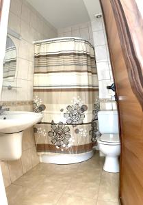 a bathroom with a toilet and a shower curtain at Family Hotel YALTA Свети Влас in Sveti Vlas