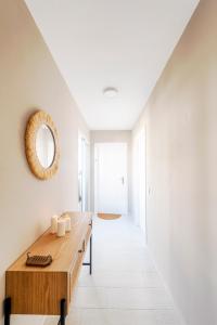 a white hallway with a wooden table and a mirror at Bella Marbella in Marbella