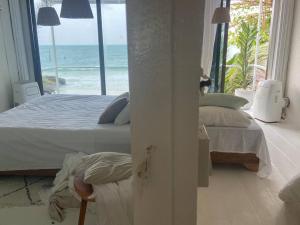 una camera con letto e vista sull'oceano di Boho Beachfront Cottage a Ban Chalok Lam