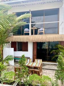 une maison avec deux chaises et une table sur un balcon dans l'établissement Boho Beachfront Cottage, à Chaloklum