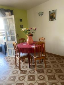 a dining room table with a vase of flowers on it at Maison de 2 chambres avec terrasse amenagee et wifi a Sainte Luce a 1 km de la plage in Sainte-Luce