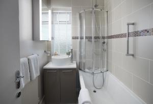 a bathroom with a sink and a glass shower at Stella in Marcross +19 photos