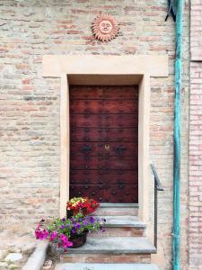 a wooden door on the side of a building with flowers at Rustico Via del Sole 13 in Amandola
