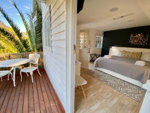 a bedroom with a bed and a table on a deck at Vida Nova Retreat in Cape Town