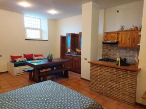 Habitación con cocina, mesa y sofá. en Rustico Via del Sole 13, en Amandola