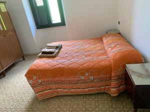 ein Schlafzimmer mit einem großen Bett mit einer orangefarbenen Decke in der Unterkunft CASA VACANZA POLI in Ascoli Piceno