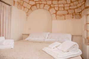 a bedroom with two white towels on a bed at Micele Holiday Houses in Locorotondo