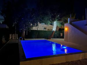una piscina por la noche con iluminación azul en Casa Eucaliptus en L'Eucaliptus