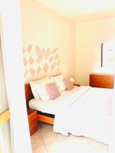 a bedroom with a white bed with two pillows at Eleonora Home in Porto Torres
