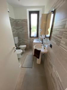 a bathroom with a sink and a toilet and a mirror at CASA VACANZA POLI in Ascoli Piceno