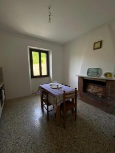 ein Wohnzimmer mit einem Tisch und einem Kamin in der Unterkunft CASA VACANZA POLI in Ascoli Piceno