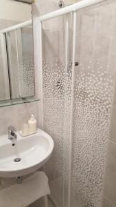 a white bathroom with a shower and a sink at Hotel Trifoglio in Lido di Jesolo