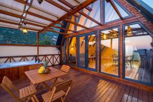 Casa con terraza de madera con mesa y sillas en Hidden Bungalow en Kas