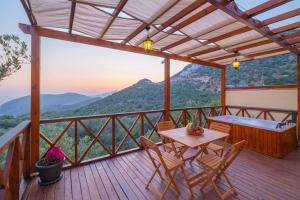 a deck with a table and chairs and a view of a mountain at Hidden Bungalow in Kaş