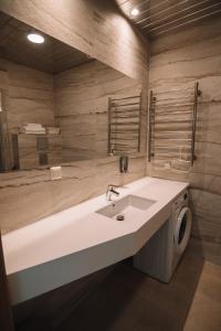 La salle de bains est pourvue d'un lavabo et d'un lave-linge. dans l'établissement Merepargi ApartHotel & Cafe, à Narva-Jõesuu
