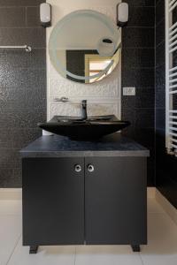 a bathroom with a black sink and a mirror at CASA DE LA MUNTE in Frumosu +30 photos