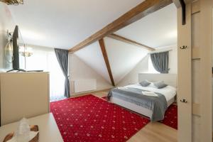 a bedroom with a bed and a red rug at CASA DE LA MUNTE in Frumosu