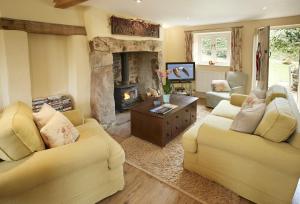 a living room with two couches and a fireplace at Orchard Cottage Monmouthshire 