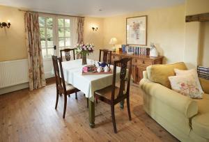 uma sala de jantar com uma mesa e um sofá em Orchard Cottage Monmouthshire 