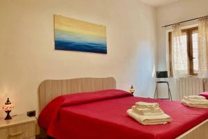 1 dormitorio con cama roja y manta roja en Vivo il Centro, en Praia a Mare