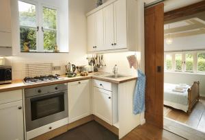 Una cocina con gabinetes blancos y un fregadero. en Owl House, en Wadebridge