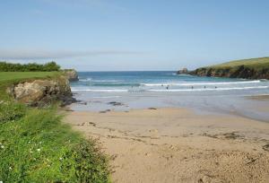 una playa con gente surfeando en el océano en Owl House, en Wadebridge 13 fotos más