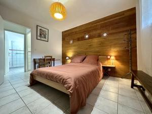 a bedroom with a large bed with a wooden wall at Gîte de NOE au Ray-pic in Péreyres
