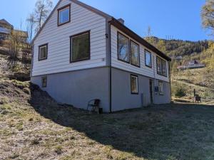 una casa blanca en la cima de una colina en Holiday home - Your dream vacation awaits in Massfjorden, en Masfjorden