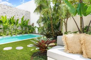 a garden with a swimming pool in a yard at Casa Umalas Villa by Betterplace in Canggu