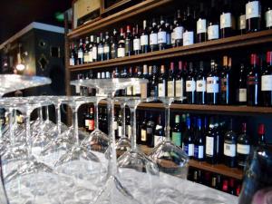una fila de copas de vino sentadas en un mostrador con botellas de vino en Ca’Bosello Ristorante e locanda, 