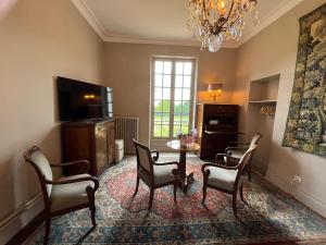 a living room with a table and chairs and a chandelier at Domaine de Charnay Plaisance Sologne in Vierzon