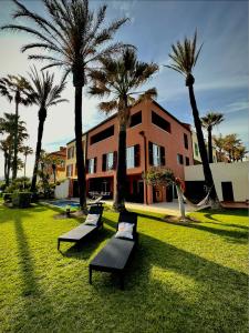 un groupe de bancs dans un champ planté de palmiers dans l'établissement Casa Arlequin, à Sotogrande