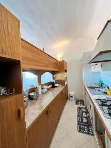 a kitchen with wooden cabinets and a counter top at bilocale vista porto in Cannigione