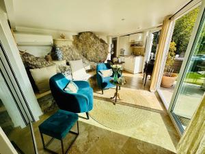 uma sala de estar com duas cadeiras azuis e um sofá em Gîte Les Deux Roches em Le Bar-sur-Loup
