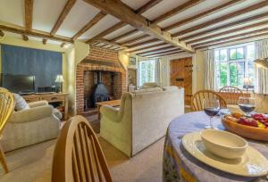 a living room with a table and a fireplace at Holly Cottage in Huntingfield
