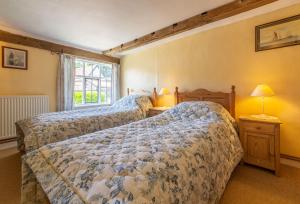 a bedroom with two beds and a window at Holly Cottage in Huntingfield