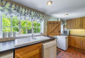 a kitchen with a sink and a window at Holly Cottage in Huntingfield