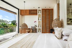 チャングーにあるCasa Umalas Villa by Betterplaceの大きなベッドと大きな窓のある寝室