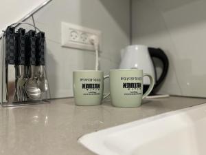 zwei Kaffeetassen auf einer Theke in einer Küche in der Unterkunft דירת 2 חדרים in Bat Yam