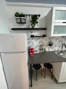 uma pequena cozinha com uma mesa e duas cadeiras em Perla Home - Studio 22 em Popeşti-Leordeni