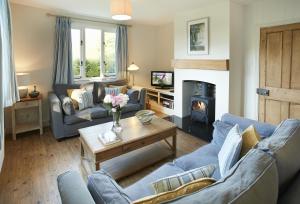 a living room with blue couches and a fireplace at Tufton Croft in Wittersham