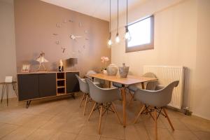 a dining room with a table and chairs and a clock at Iasonas House 85m2 in Preveza