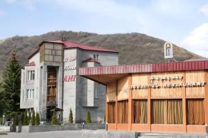 un gran edificio con una montaña en el fondo en Jermuk Ani Hotel, en Jermuk