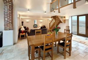 comedor y sala de estar con mesa y sillas en Blagdon Lower Barn, en Winterborne Steepleton