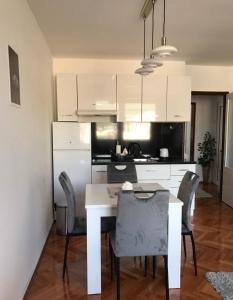 a kitchen with a white dining room table and chairs at Apartman Snezana in Pirot