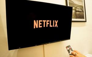 a person holding a remote control in front of a television at The Maltese Sun in Sliema
