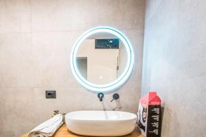Un baño con un lavabo blanco y un espejo. en Basilica Suite, en Bari