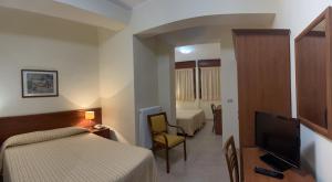 a hotel room with two beds and a flat screen tv at Il Nocchiero City Hotel in Soverato Marina