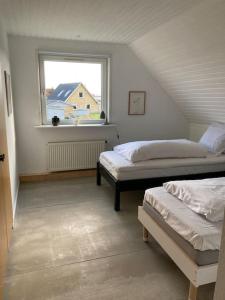 Apartment with a unique view في Vestervig: غرفة علوية بسريرين ونافذة